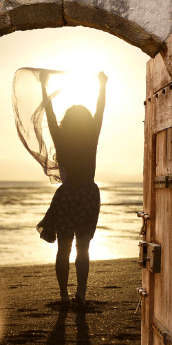 woman with outstretched arms on the beach